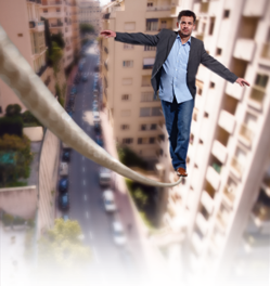 Man balancing on a rope between two towers